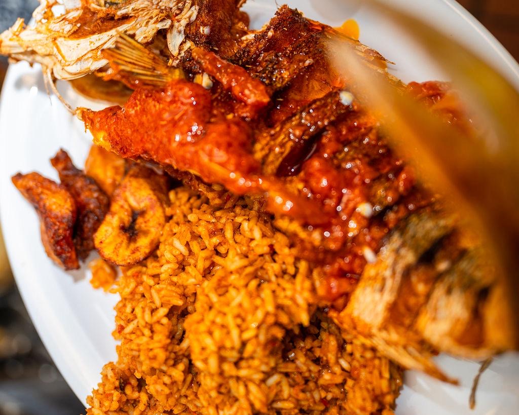 Close-up of jollof rice with grilled fish and plantain